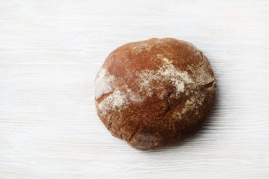Freshly baked bread on light wood table background. Top view. Flat lay.