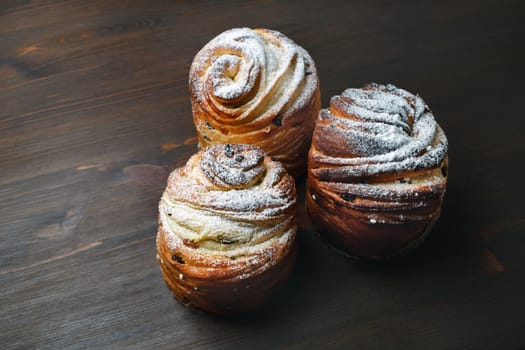 Three sweet buns on wood table background.