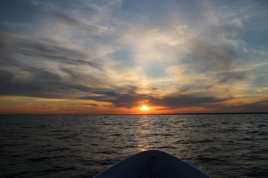 evening at sea setting sun on the course of the boat,  dramatic cloudy landscape