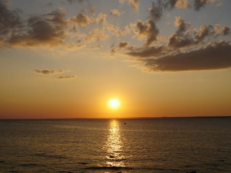 yellow sun sets over the sea and dusk falls