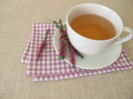 A cup of heather tea and flowering shoots from calluna vulgaris
