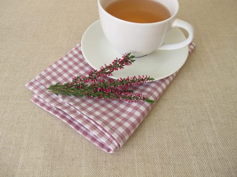 A cup of heather tea and flowering shoots from calluna vulgaris