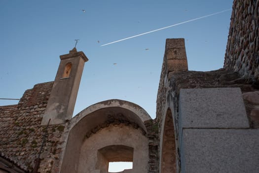 Galisteo, beautiful walled town from Alagon Valley. Swifts flying over Puerta de la Villa. Extremadura, Spain