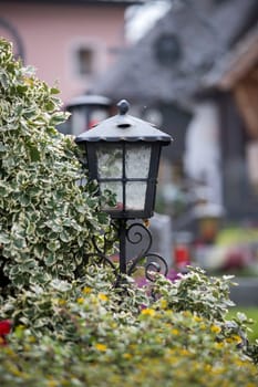 Candle in an iron lantern on a grave at a cemetery