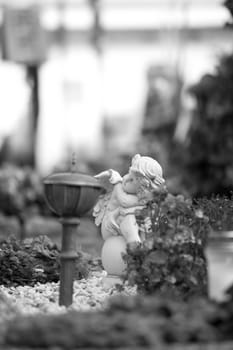 White angel on a grave at a cemetery, flowers