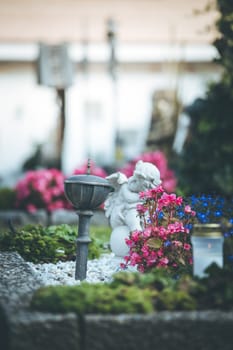 White angel on a grave at a cemetery, flowers