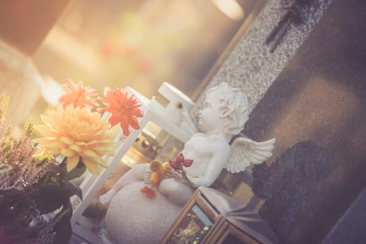 White angel on a grave at a cemetery, flowers