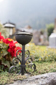 Iron holy water bowl on a cemetery