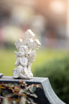 White angel on a grave at a cemetery, flowers