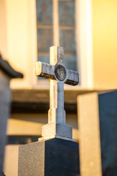White Stone cross on a grave, evening sun