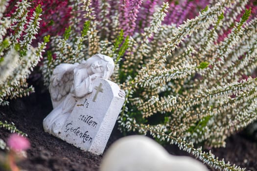 White angel on a grave at a cemetery, flowers