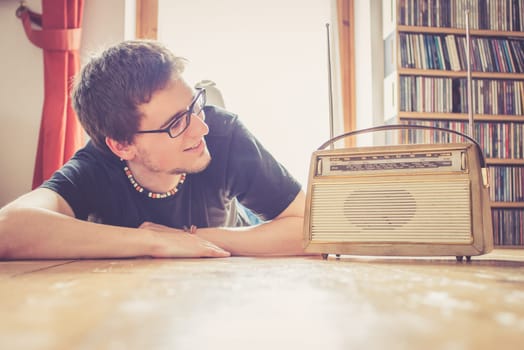 Young man listeining to an retro radio