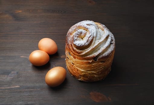 Delicious sweet bun and eggs on wooden background.