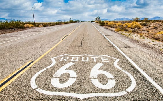 Route 66 road sign with blue sky background. Historic street with nobody. Classic concept for travel and adventure in a vintage way.