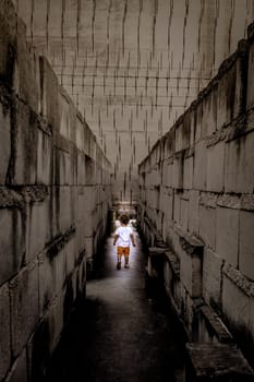 Caucasian young kid walking with labyrinth perspective. Conceptual image for dangerous situation during childhood.
