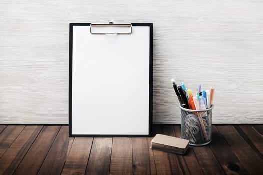 Photo of stationery set. Clipboard with blank letterhead, cup holder with pencils and pens, business cards. Copy space for text.