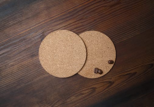 Blank beer coasters and coffee beans on wood table background. Top view. Flat lay.