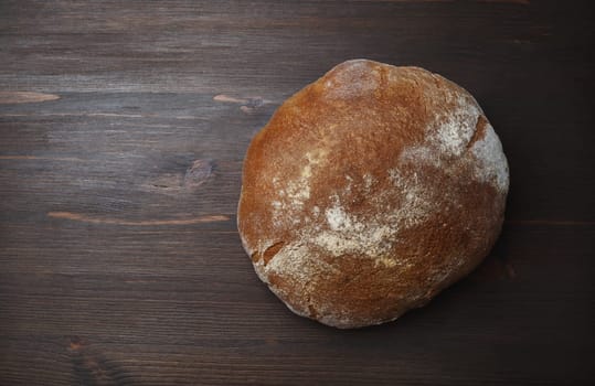 Freshly baked traditional bread on wooden background. Flat lay.