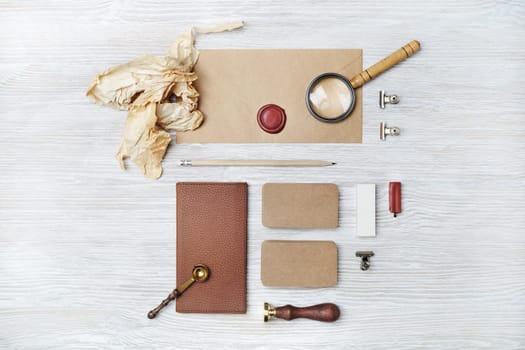 Photo of blank vintage stationery on light wood table background. Space for text. Flat lay.