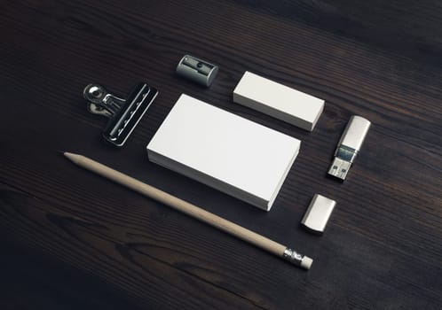 Photo of blank business cards, pencil, eraser and flash drive on wooden background. Blank stationery set.