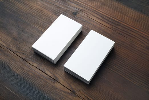 Photo of blank business cards on wooden background. Template for branding identity.