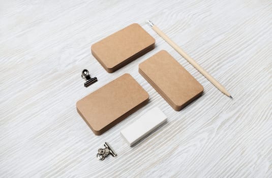 Blank vintage business cards, pencil and eraser on light wooden background. ID template. Mock-up for branding identity for designers.