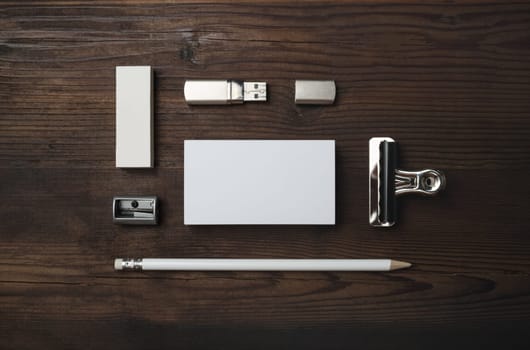 Branding mock up. Blank business card, flash drive, pencil, eraser and sharpener on wood table background. Flat lay.