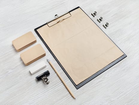 Photo of blank kraft stationery set on light wooden background. Business brand template. Branding mock up.