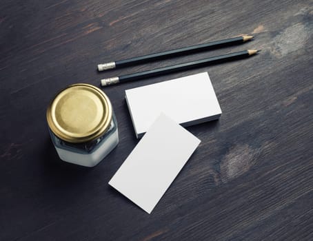 Stationery mock up. Blank business cards, pencils and jar on wood table background.