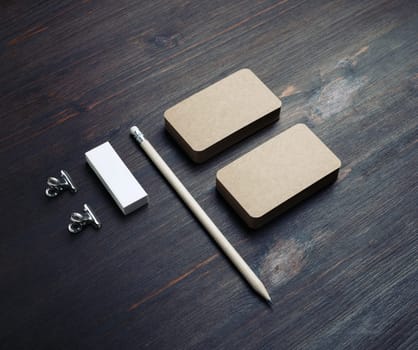 Blank kraft stationery set. Blank vintage business cards, pencil and eraser on wood table background.
