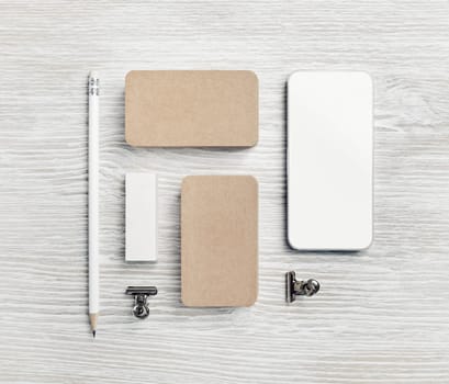 Blank corporate identity set. Smartphone, kraft business cards, pencil and eraser. Top view. Flat lay.