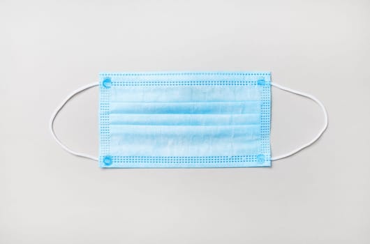 Medical face mask on paper background. Corona virus protection. Top view. Flat lay.