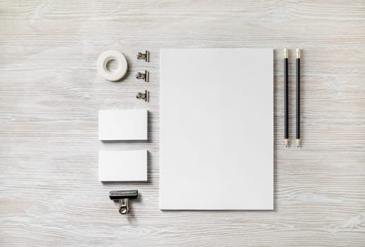 Blank corporate stationery template on light wood table background. Mockup for design presentations and portfolios. Flat lay.