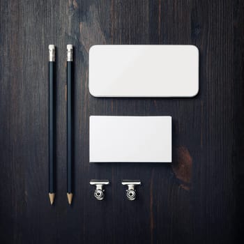 Branding id template. Blank business card, smartphone, pencils and paper clips. Flat lay.