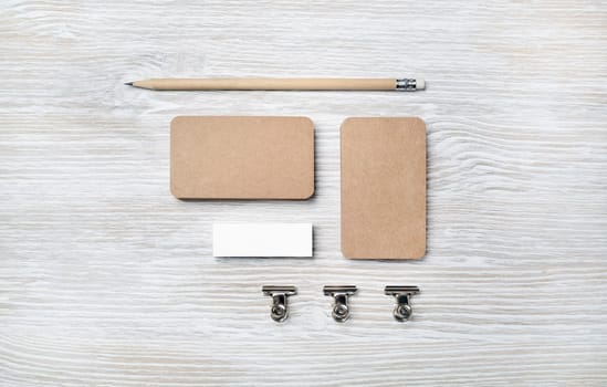 Blank vintage business cards, pencil and eraser on light wooden background. Branding ID mockup. Top view. Flat lay.
