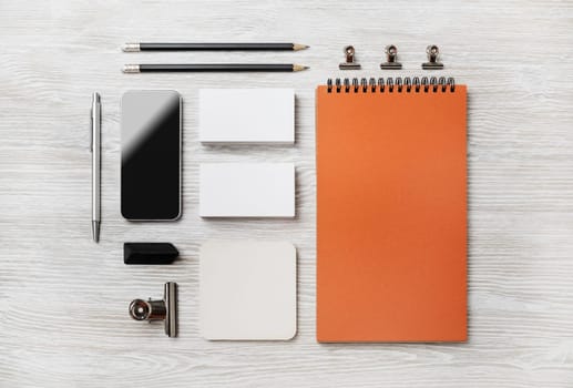Photo of blank stationery set on light wood table background. Corporate identity template. Responsive design mockup. Top view. Flat lay.