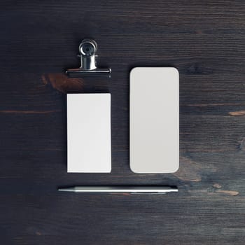 Blank branding template. Blank business card, pen and smartphone on wood table background. Flat lay.