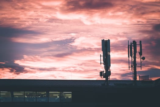Transmitter antennas in the evening. Orange sky and clouds.
