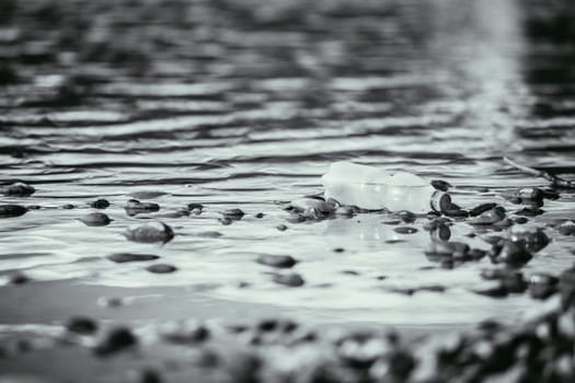 Plastic bottle is lying on the stony beach, environmental pollution