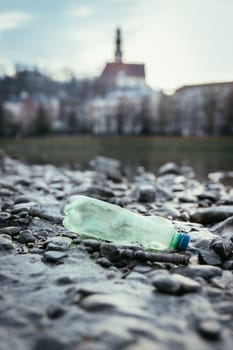 Environmental pollution: plastic bottle on the beach, urban city