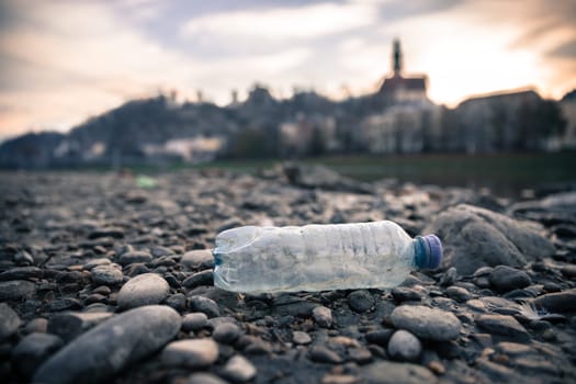 Environmental pollution: plastic bottle on the beach, urban city
