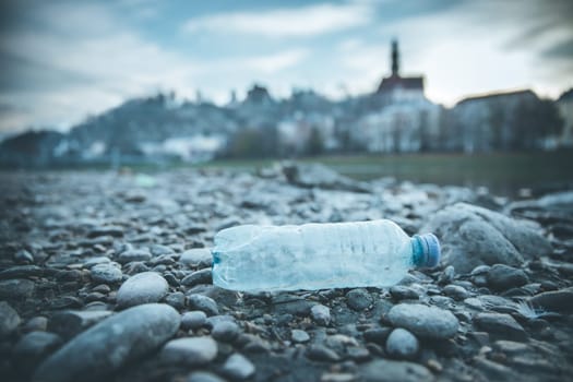 Environmental pollution: plastic bottle on the beach, urban city