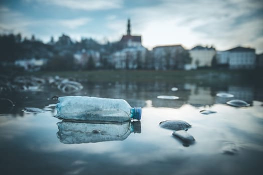 Environmental pollution: plastic bottle on the beach, urban city