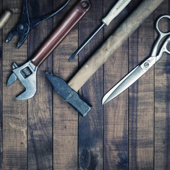 Old used tools on vintage wooden background. Top view. Flat lay.