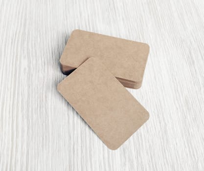Photo of blank vintage business cards on light wooden background. Template for ID.