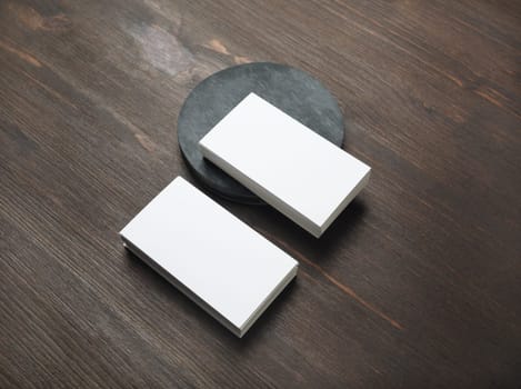 Photo of blank business cards on wood table background. Template for branding identity.