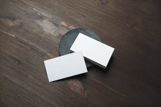 Blank white business cards on wood table background. Mockup for branding identity. Template for graphic designers portfolios.