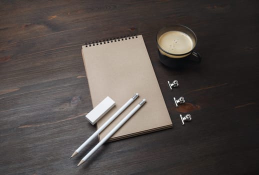 Blank stationery template. Blank kraft notebook, coffee cup, pencil and eraser on wood table background.