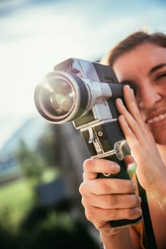 Girl is recording a movie, vintage old movie camera