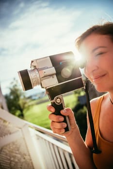 Girl is recording a movie, vintage old movie camera